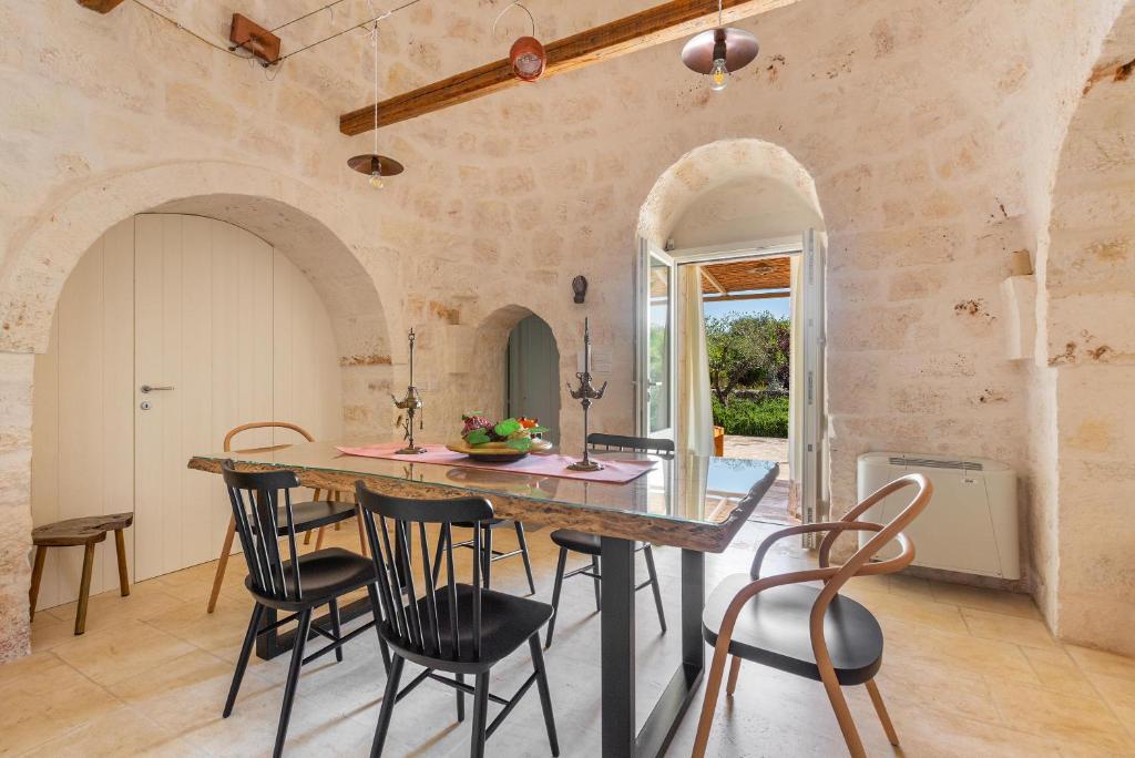 une cuisine avec une grande table et des chaises dans l'établissement Trulli Almaviva by Perle di Puglia, à Cisternino