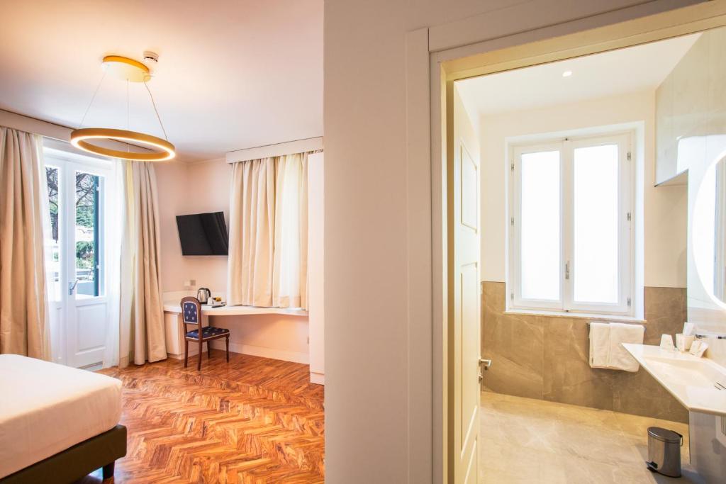 une salle de bain avec un lit, un lavabo et un miroir dans l'établissement Villa Maria Teresa Boutique Hotel, à Formia