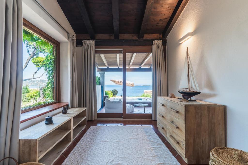 Cette chambre dispose d'une grande fenêtre offrant une vue sur l'océan. dans l'établissement Villa Caterina, à Monte Petrosu
