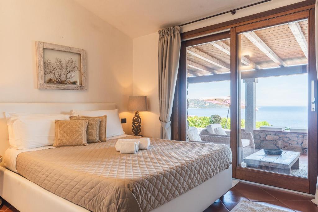 une chambre avec un lit avec vue sur l'océan dans l'établissement Villa Caterina, à Monte Petrosu
