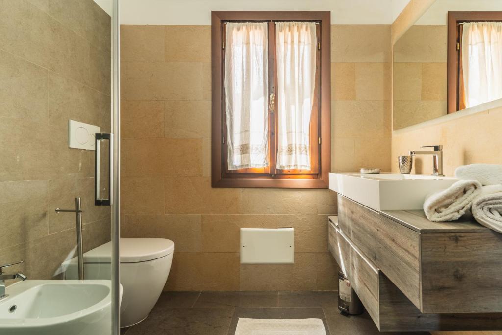 une salle de bain avec toilettes, lavabo et baignoire dans l'établissement Villa Caterina, à Monte Petrosu