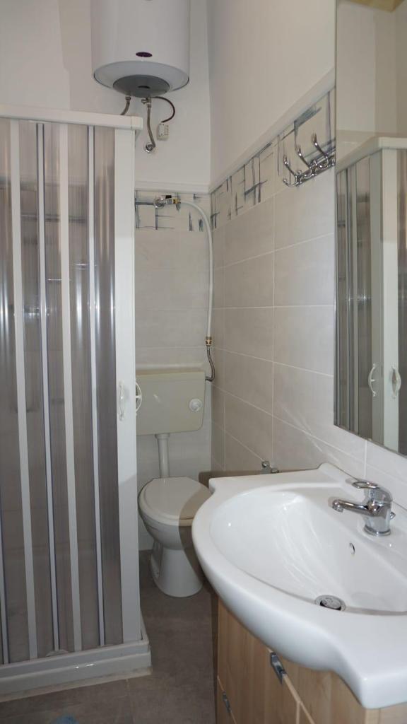 une salle de bain avec un lavabo et des toilettes dans l'établissement Puffolandia House, à Contrada Maeggio