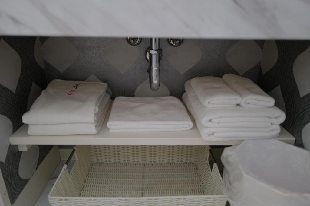 - une salle de bains pourvue de serviettes blanches sur une étagère dans l'établissement HOTELO OTONA no ASOBIBA, à Yosano 17 autres photos