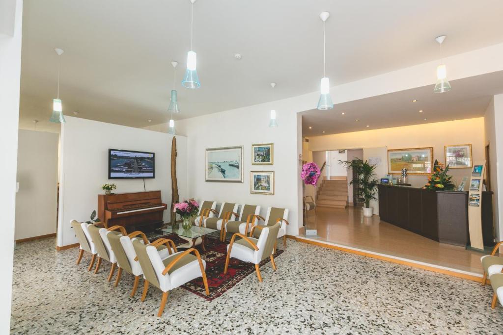 une salle d'attente avec une table et des chaises dans l'établissement Hotel Colonna, à Lido di Jesolo