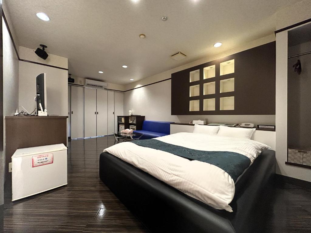 une chambre avec un grand lit dans une pièce dans l'établissement Hotel MGM, à Niigata