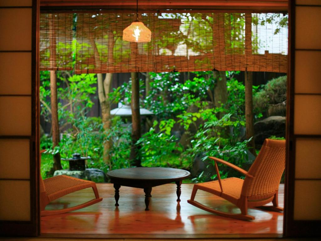 une chambre avec deux chaises, une table et une fenêtre dans l'établissement Hanakanzashi, à Nihommatsu