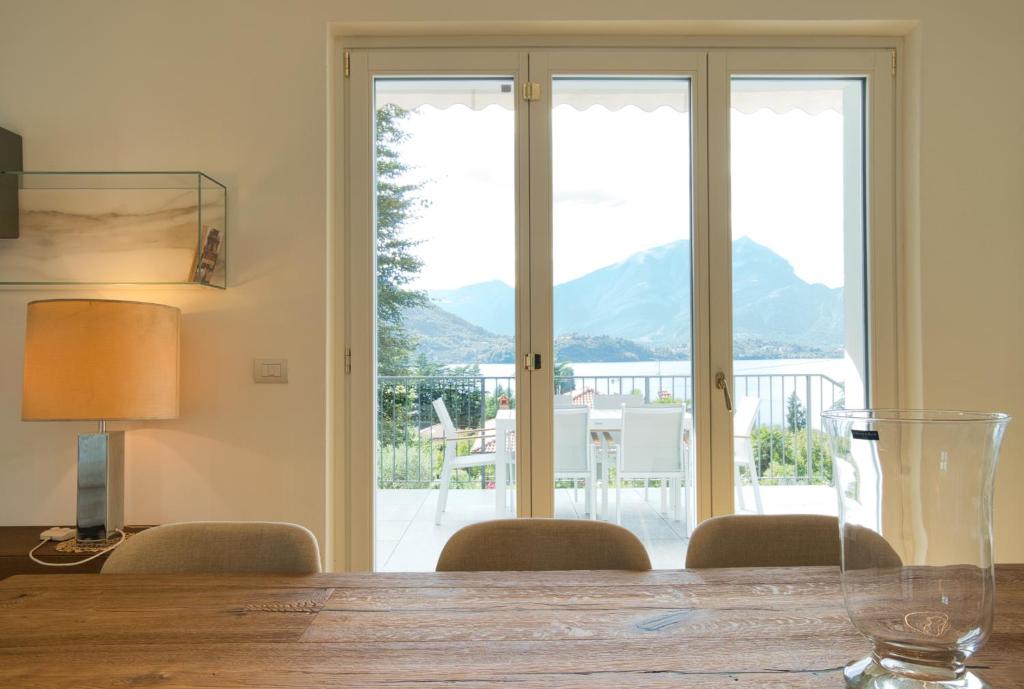 d'une salle à manger avec une table, des chaises et une fenêtre. dans l'établissement Hidden Gem - Villa with private swimmingpool Bellagio view, à Lierna