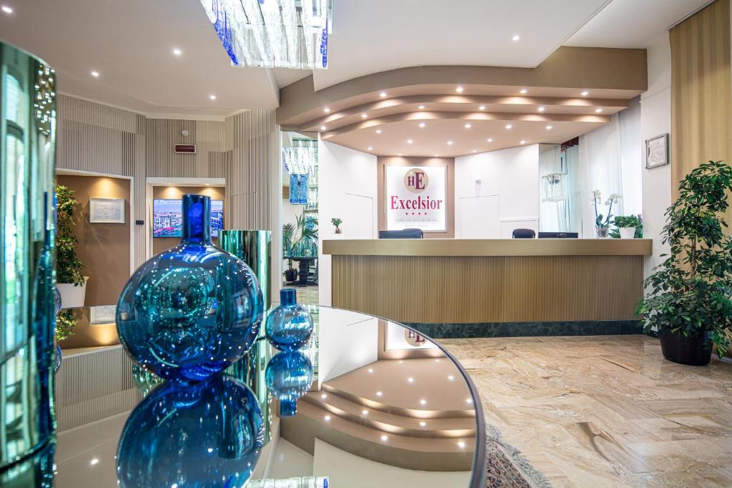 un vase en verre bleu posé sur une table en verre dans un magasin dans l'établissement Hotel Excelsior, à Bibione 98 autres photos