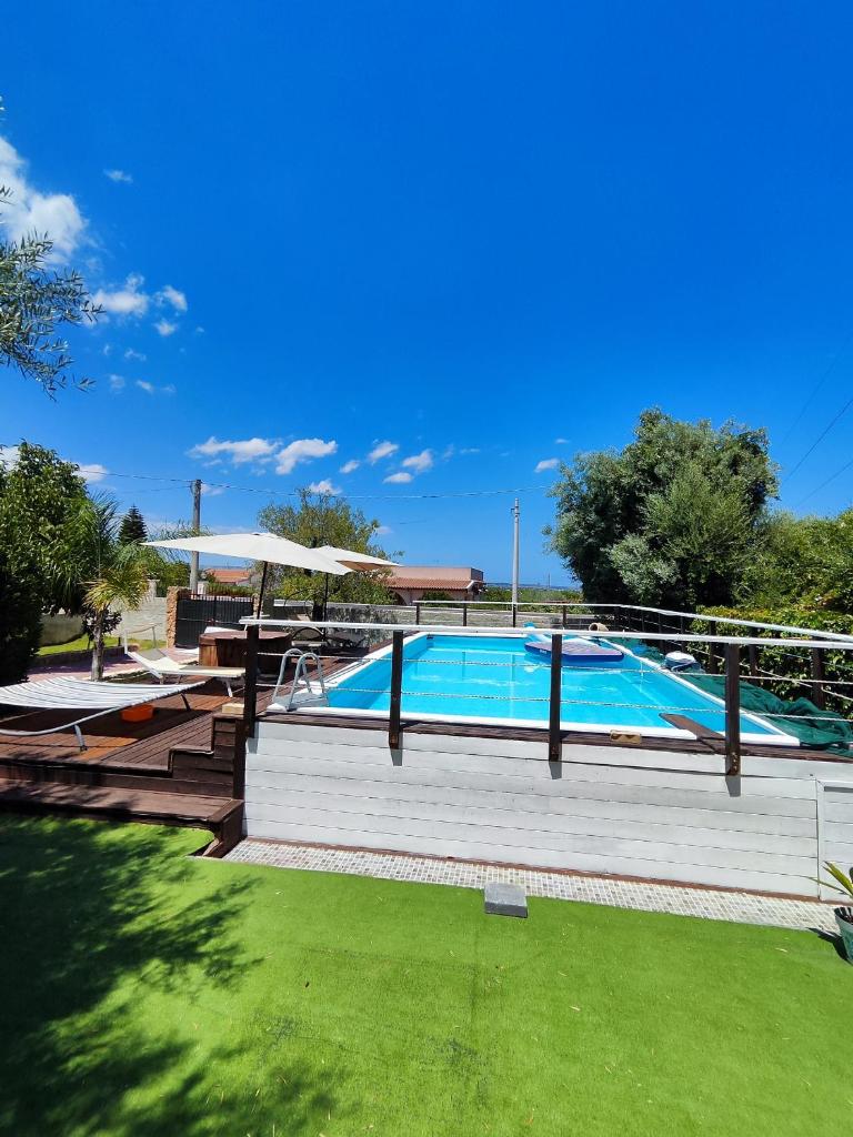 - une grande piscine avec une table de pique-nique et des bancs dans l'établissement Puffolandia House, à Contrada Maeggio