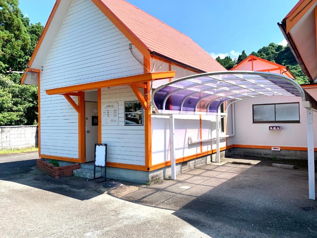 un bâtiment avec un auvent en haut dans l'établissement JOY GARDEN, à Taku