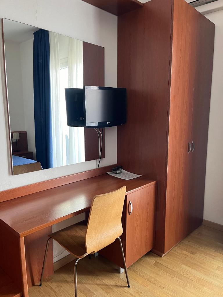 Cette chambre comprend un bureau avec une télévision et un miroir. dans l'établissement Hotel Silva Frontemare, à Lido di Jesolo