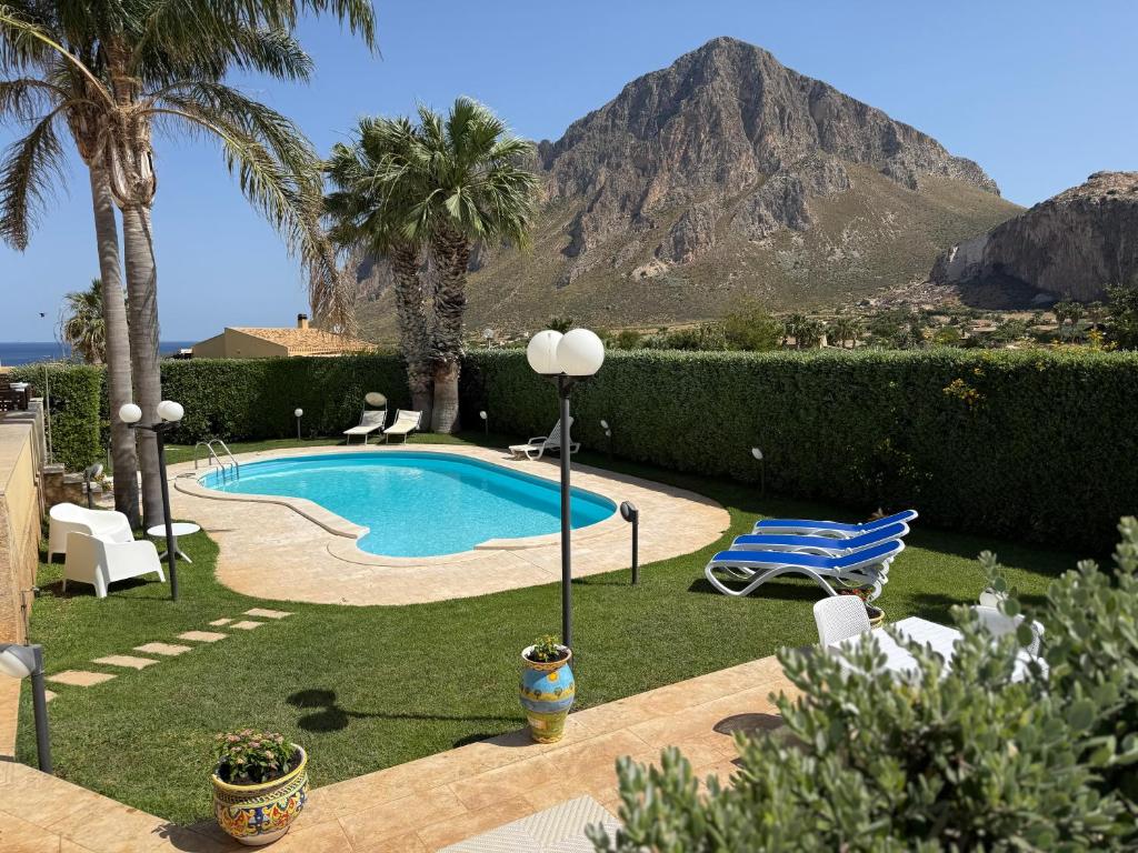 - une piscine dans une cour avec une montagne en arrière-plan dans l'établissement Le Case di Palma - Villa Maria, à Custonaci