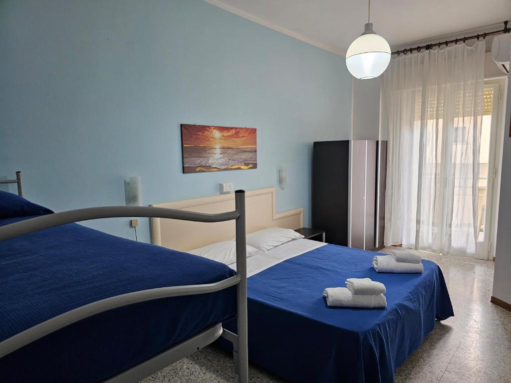 une chambre avec un lit avec deux serviettes dessus dans l'établissement Hotel Riviera Nuova Gestione, à Cattolica