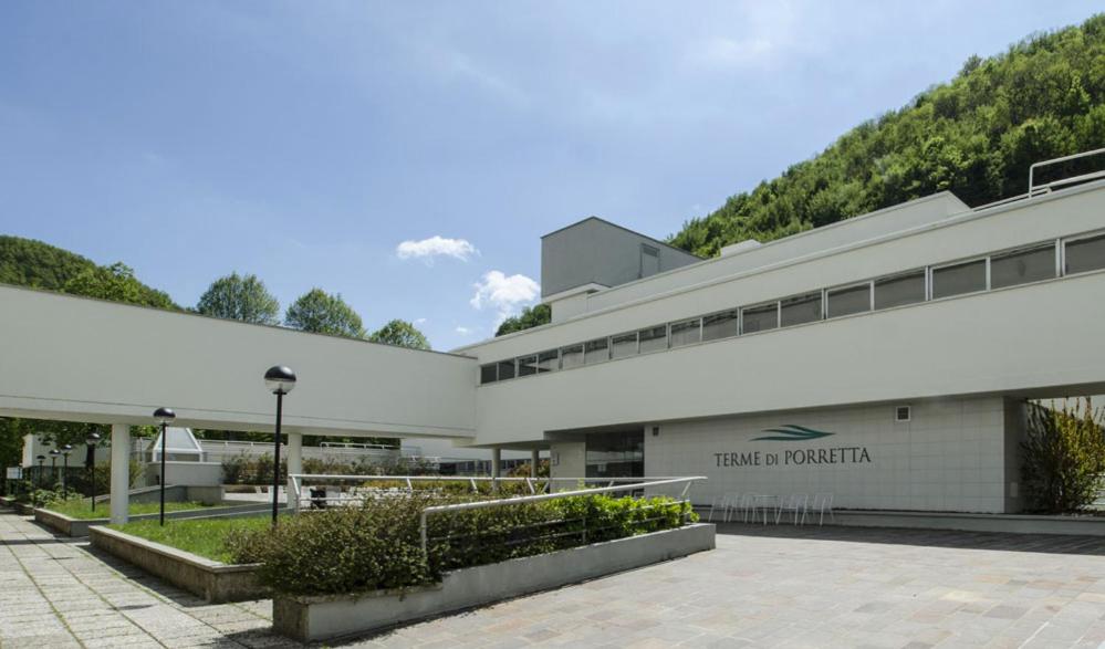 un grand bâtiment blanc avec une montagne en arrière-plan dans l'établissement La Panoramica a Molino del Pallone, à Molino del Pallone