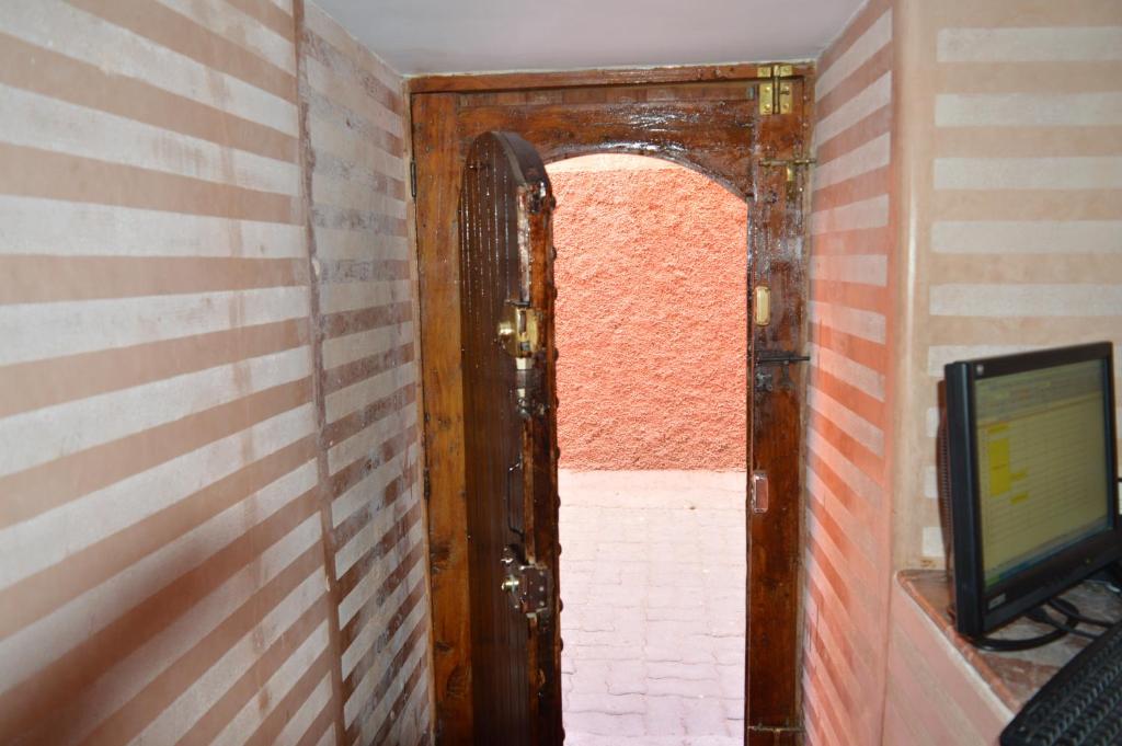 - une porte ouverte dans une chambre dotée d'une télévision dans l'établissement Riad Bonheur, à Marrakech