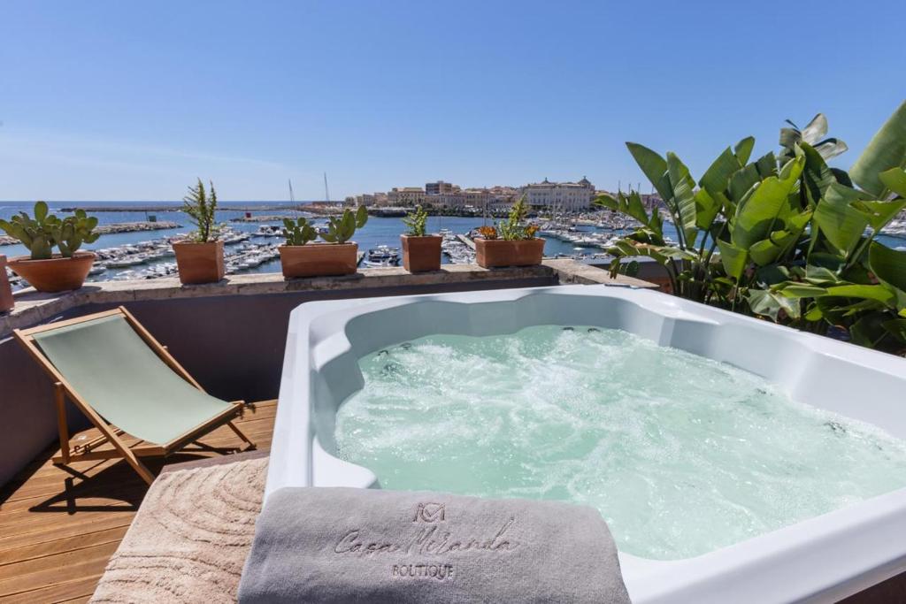 - un bain à remous sur une terrasse avec une chaise et l'océan dans l'établissement Casa Miranda Boutique, à Syracuse