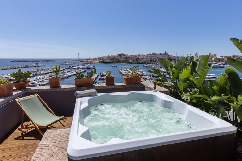 d'une baignoire sur un balcon avec vue sur l'eau. dans l'établissement Casa Miranda Boutique, à Syracuse