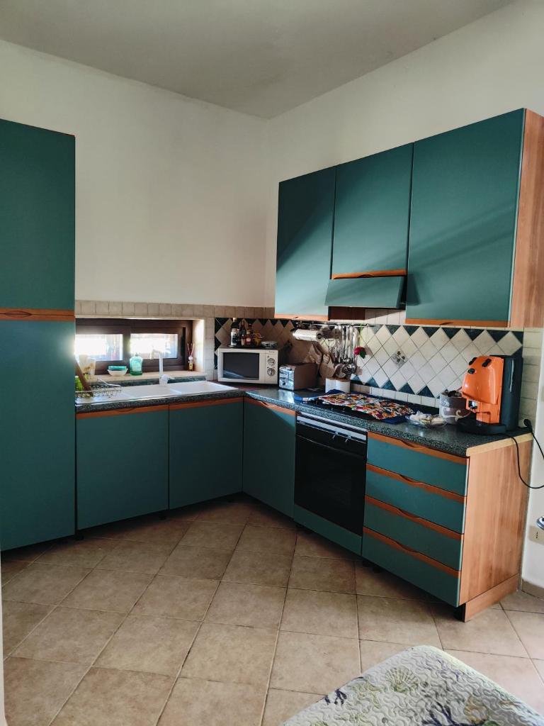 une cuisine avec des armoires vertes et une cuisinière four supérieur dans l'établissement Holiday in Paradise, à Balestrate