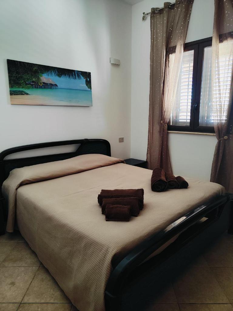 une chambre avec un grand lit avec des objets marron dessus dans l'établissement Holiday in Paradise, à Balestrate