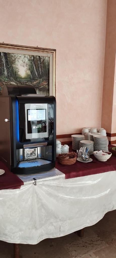 une télévision posée sur une table avec de la vaisselle dans l'établissement Hotel Acerboli, à Rimini