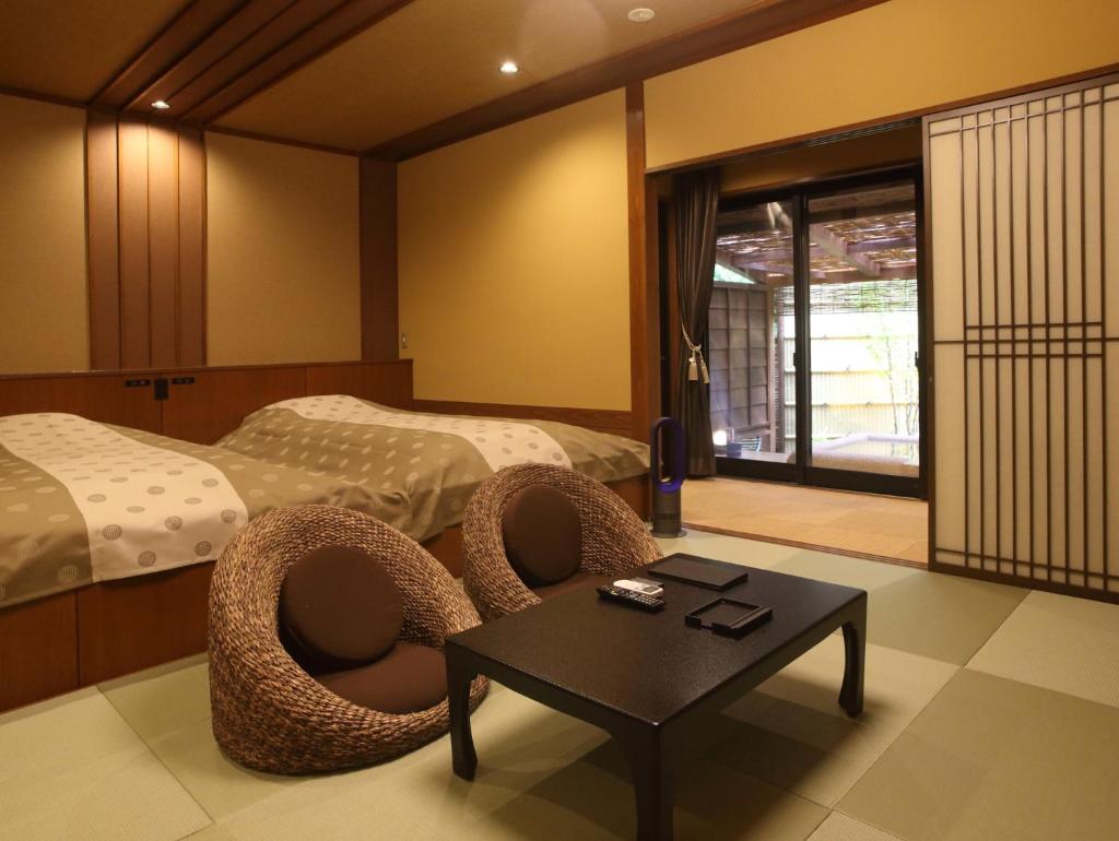 une chambre avec deux lits et une table et des chaises dans l'établissement Kanazawa Yuwaku Onsen Kokarian, à Kanazawa 91 autres photos
