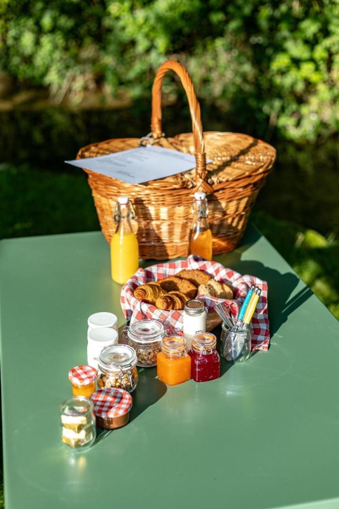 une table de pique-nique avec un panier de nourriture et de confiture dans l'établissement La Casa du Vau, à Bussy-le-Grand