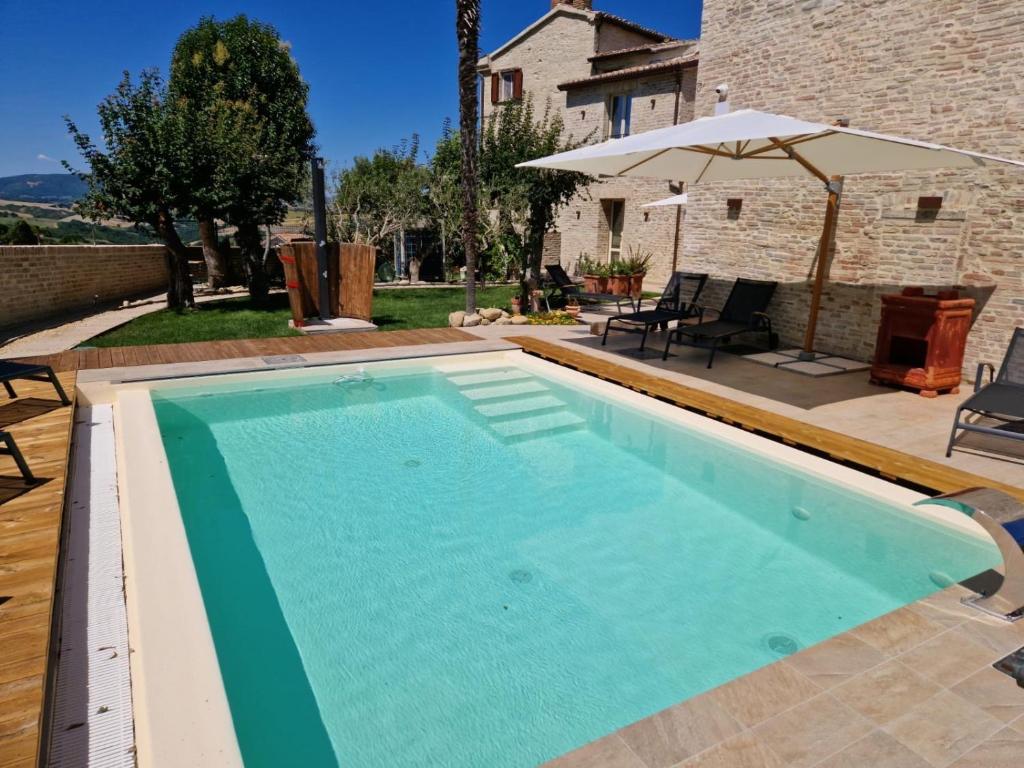 - une piscine dans un jardin avec un parasol dans l'établissement Stadthaus Felix Convivium, à Barchi