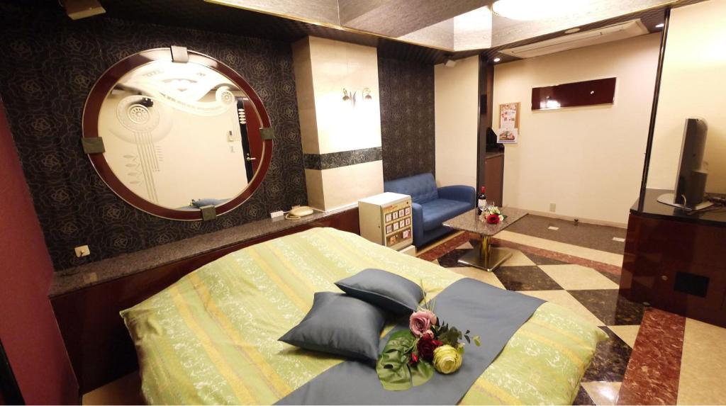 une chambre avec un lit et un grand miroir dans l'établissement HOTEL井原商事ハートランド井門 Adult only, à Tokyo