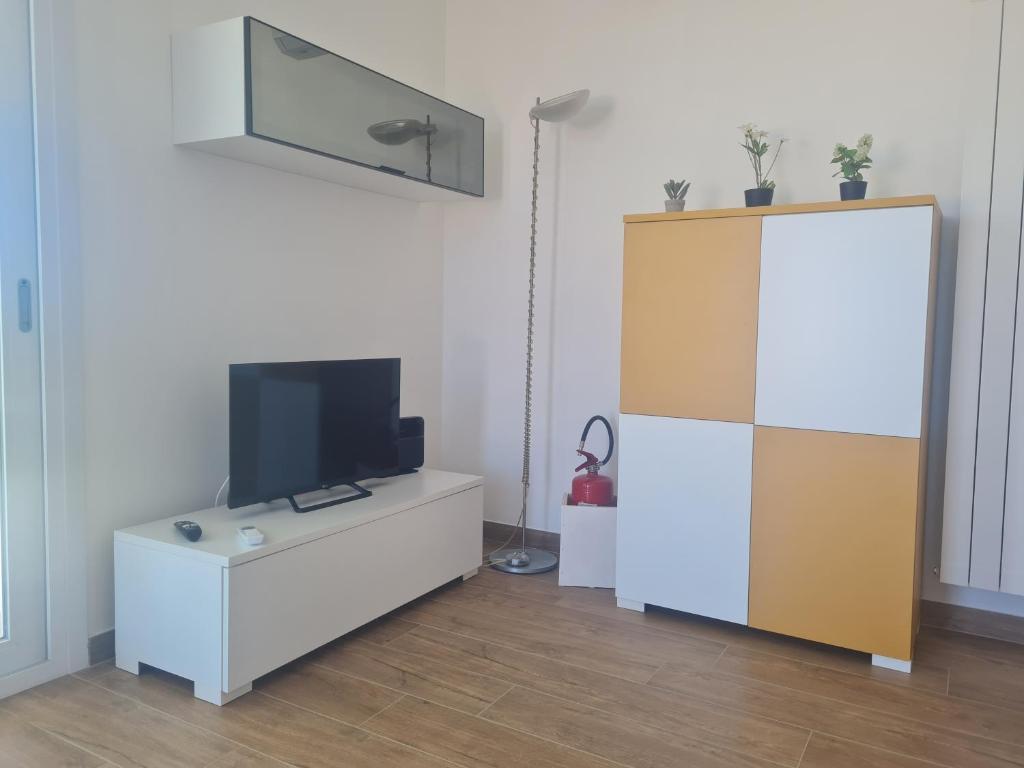 un salon avec une télévision et un meuble blanc dans l'établissement Le Saline di San Francesco, à Marausa