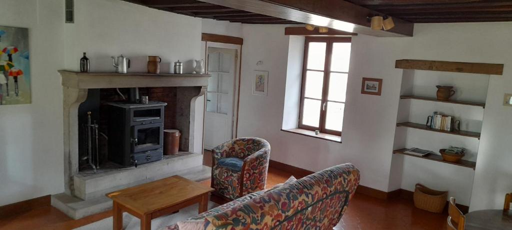 un salon avec un canapé et une cheminée dans l'établissement Gite en Forterre, à Druyes-les-Belles-Fontaines