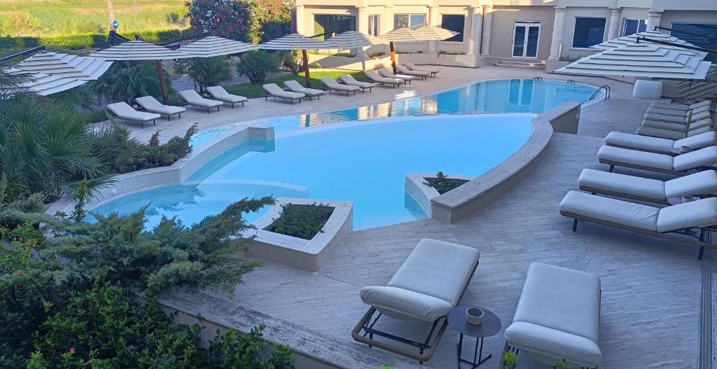 une piscine avec des chaises longues et une piscine dans l'établissement Hotel Marechiaro, à Gizzeria