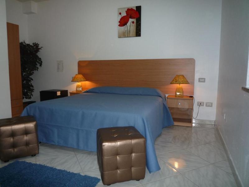 - une chambre avec un lit bleu et 2 tables de chevet dans l'établissement La Valle Verde hotel ristorante pizzeria, à Zambrone