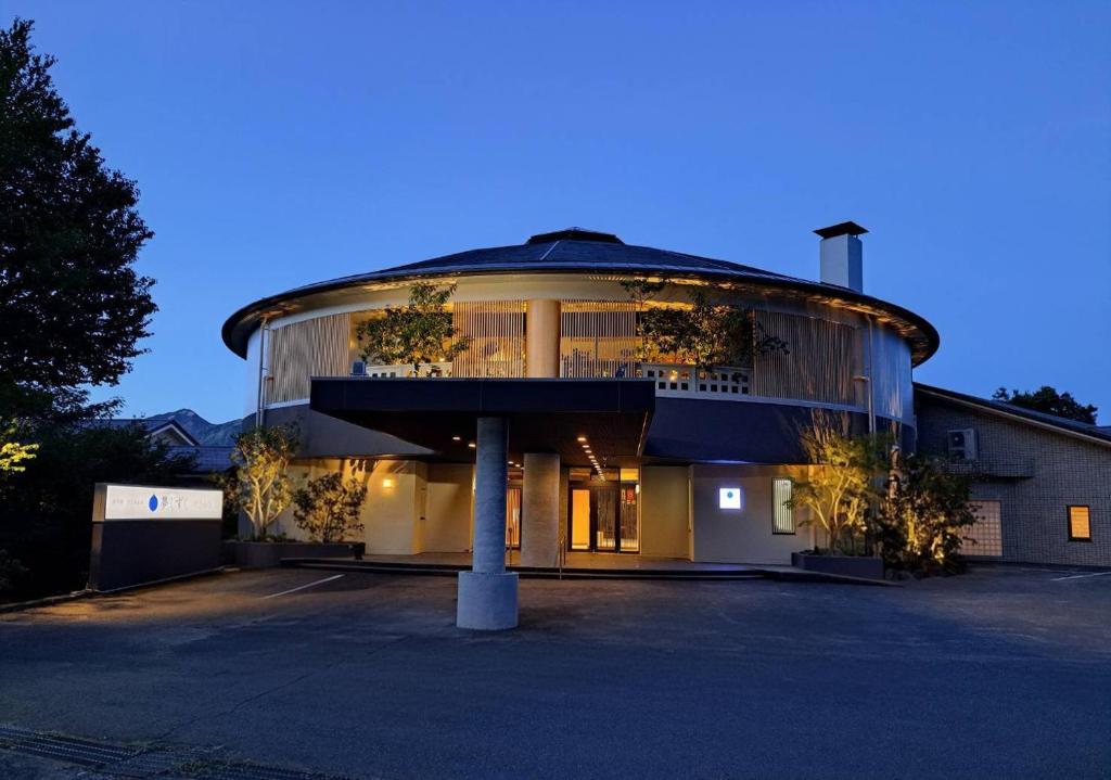 un grand bâtiment avec un toit rond avec des plantes dans l'établissement Hotel Yumeshizuku, à Minami Aso