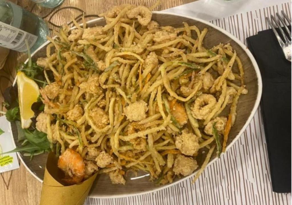 une assiette de nourriture avec des nouilles sur une table dans l'établissement Hotel Edelweiss Riccione, à Riccione