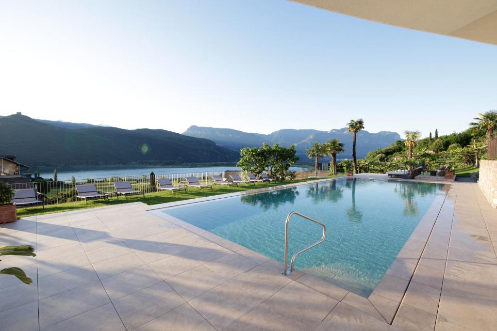une grande piscine avec vue sur le lac dans l'établissement Hotel Haus am Hang, à Caldaro