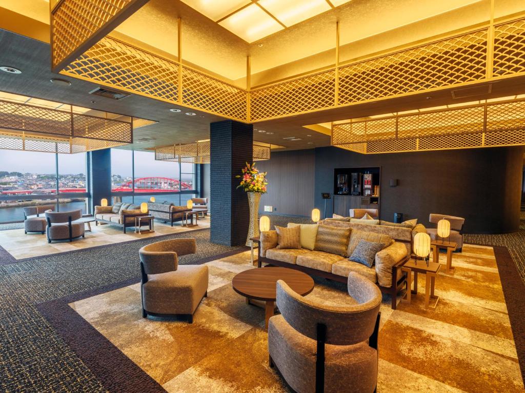 - un hall d'un hôtel avec des canapés et des chaises dans l'établissement KAMENOI HOTEL Oarai, à Ōarai