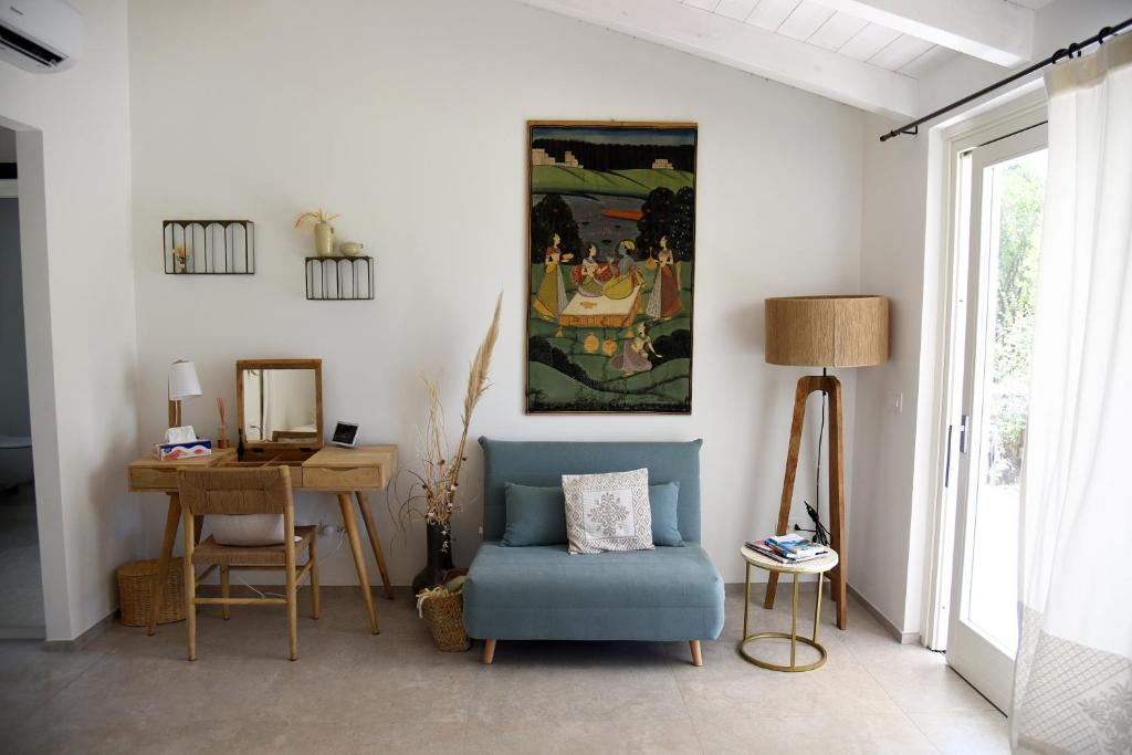 un salon avec une chaise bleue et une table dans l'établissement Exclusive Villa Bianca, à Cugnana