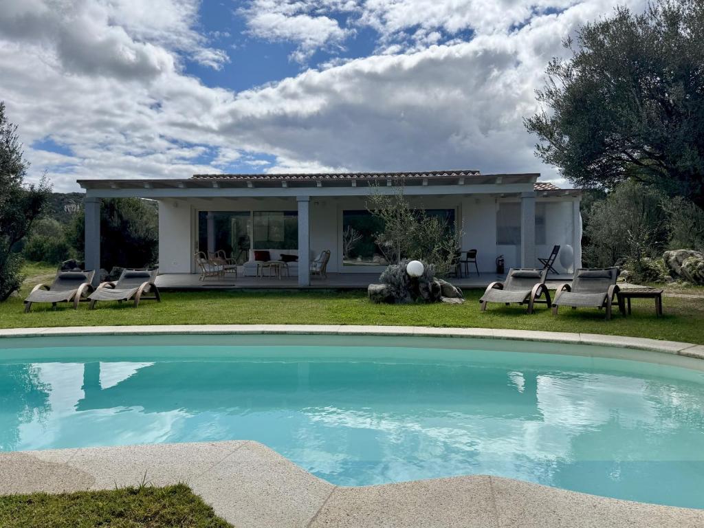une maison avec une piscine dans la cour dans l'établissement Exclusive Villa Bianca, à Cugnana