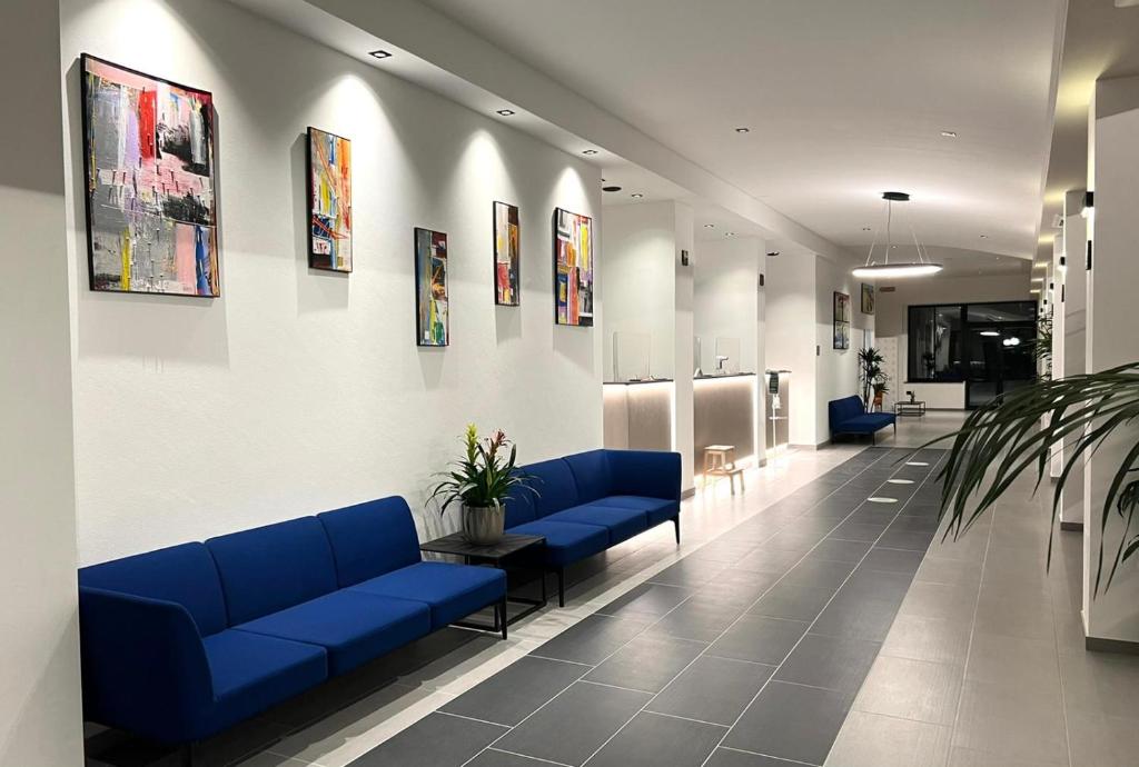 une salle d'attente avec des canapés bleus dans un hôpital dans l'établissement Hotel Palazzo Caveja, à Rimini 42 autres photos