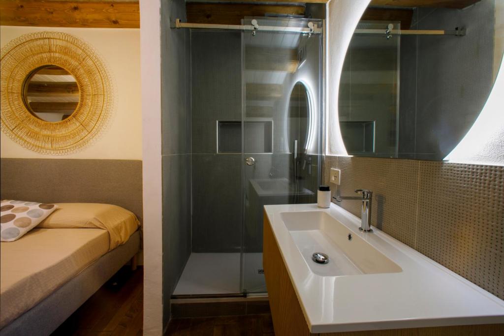 une salle de bain avec un lavabo, un lit et un miroir dans l'établissement La Dimora del Sale - Ville con piscina, à Favignana 27 autres photos