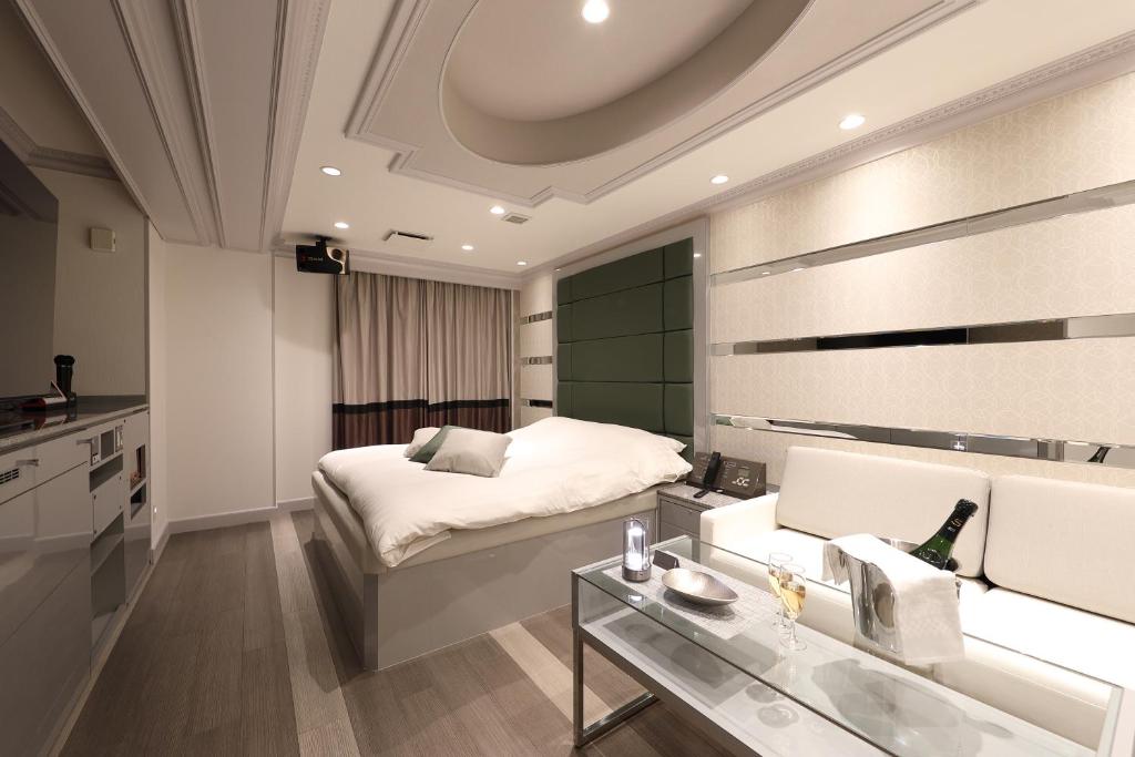 une chambre d'hôtel avec un lit et un canapé dans l'établissement Hotel Valentine Chiryu, à Chiryu