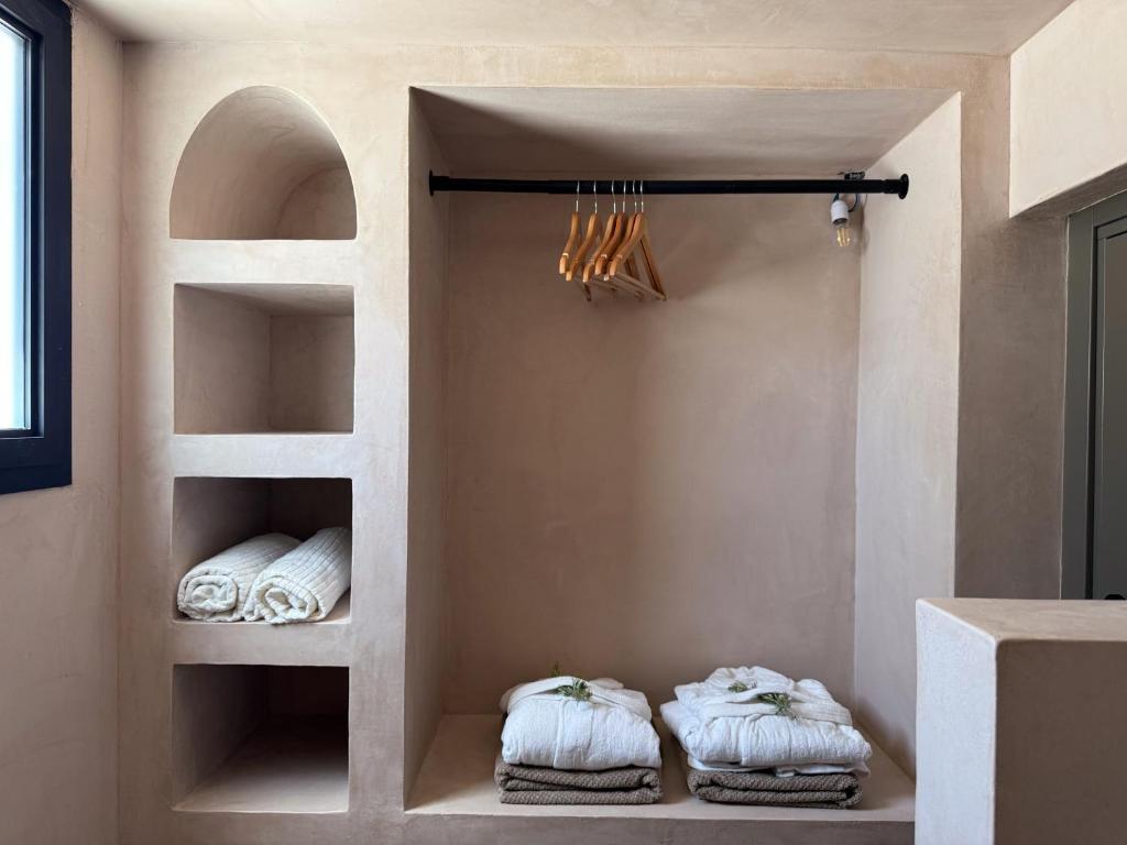 une pièce avec deux étagères avec des serviettes dans l'établissement Lumen Trullo, à Ostuni