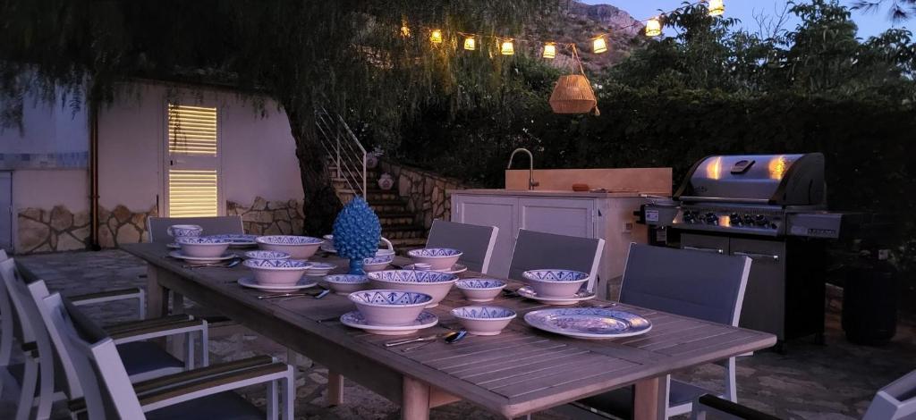 une table en bois avec des bols bleus et blancs dessus dans l'établissement Villa Ballerina Bianca, à Scopello