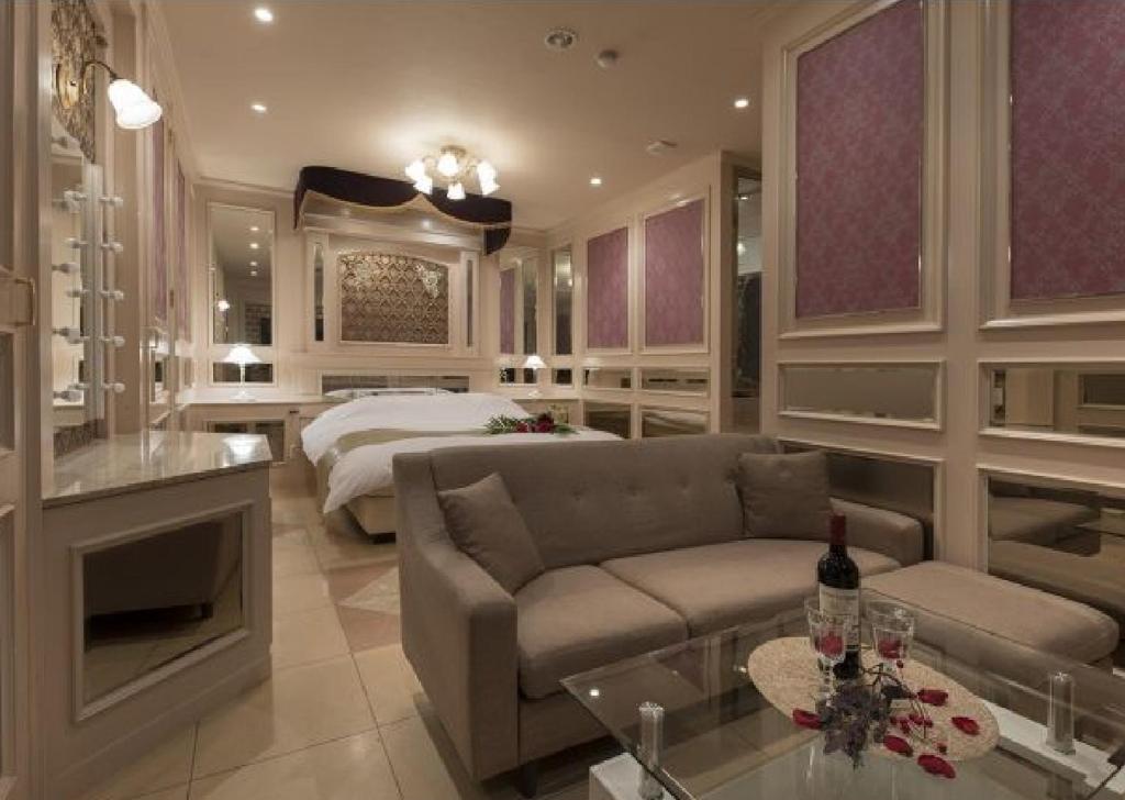 un salon avec un canapé et un lit dans l'établissement 奈良生駒市ホテル567生駒店-Adult only 大人専用-, à Ikuma
