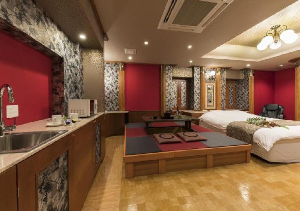 La salle de bains est pourvue d'un lavabo et d'un lit dans la chambre. dans l'établissement 奈良生駒市ホテル567生駒店-Adult only 大人専用-, à Ikuma