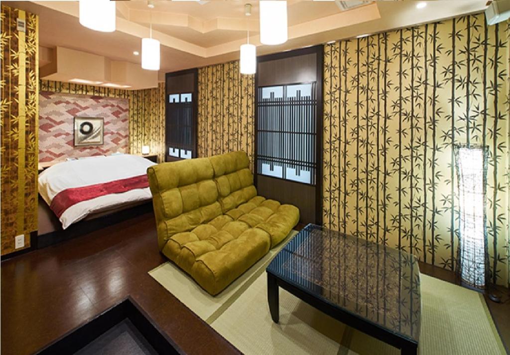 un salon avec un canapé et un lit dans l'établissement 奈良生駒市ホテル567生駒店-Adult only 大人専用-, à Ikuma