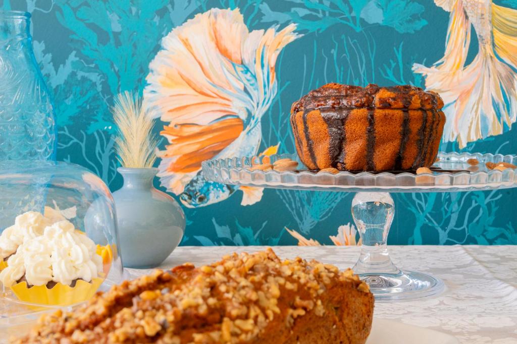 une table avec un gâteau et un cupcake sur une assiette dans l'établissement Aura Living Hotel, à Rimini