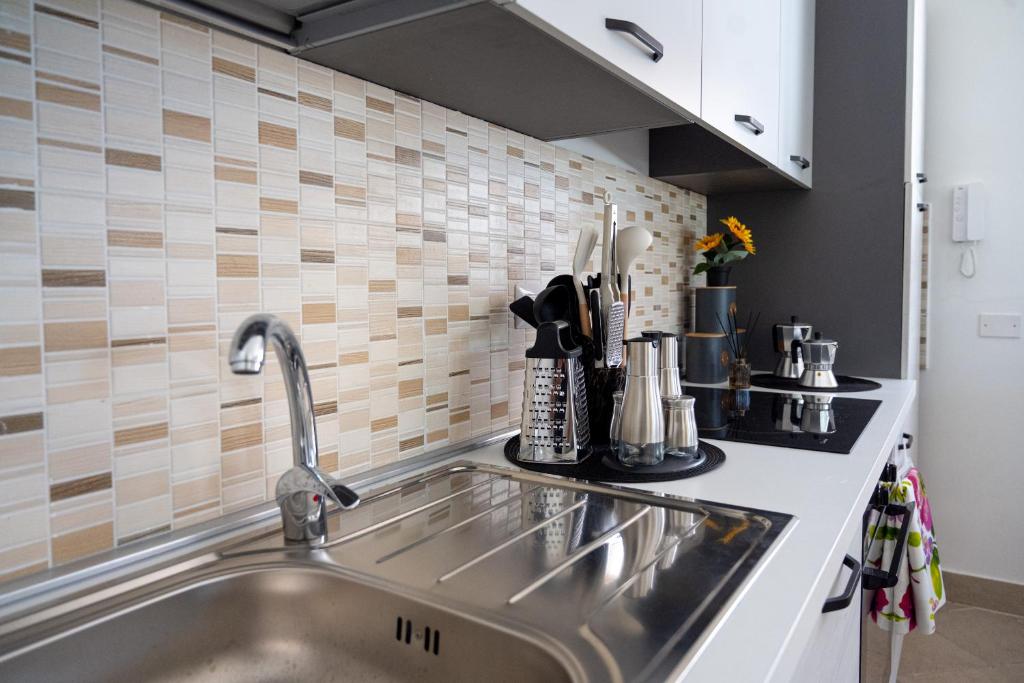 - une cuisine avec un évier en acier inoxydable et du carrelage dans l'établissement Villa Andolina, à Syracuse