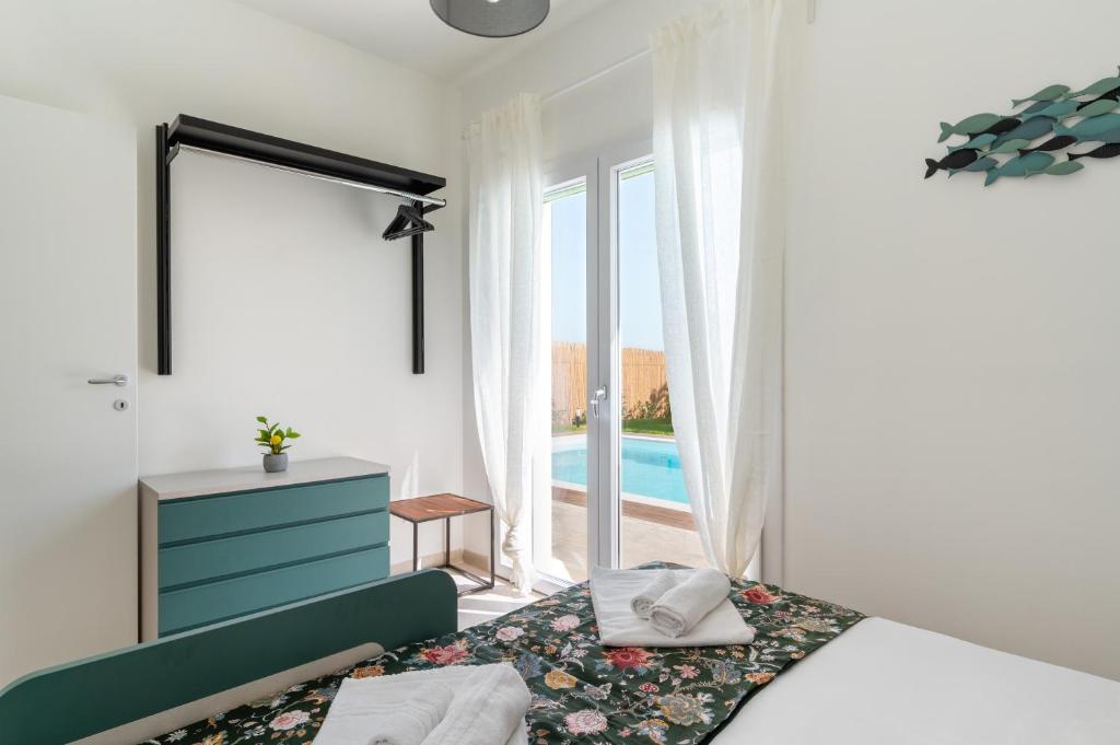 - une chambre avec un lit et une fenêtre avec une piscine dans l'établissement Villa Medusa, à Brucoli