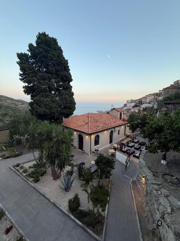 une vue aérienne d'un bâtiment avec un arbre et des bancs dans l'établissement Albergo diffuso Borgo Gallodoro da Sara, à Gallodoro